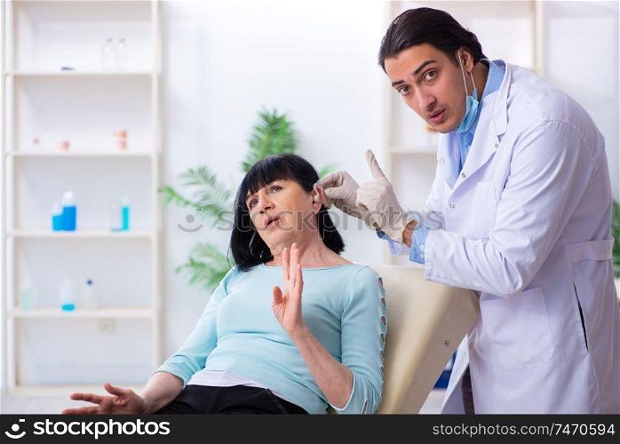 The old woman visiting young doctor laryngologist . Old woman visiting young doctor laryngologist 