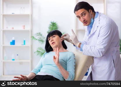 The old woman visiting young doctor laryngologist . Old woman visiting young doctor laryngologist 