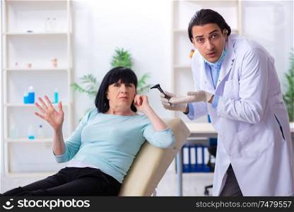 The old woman visiting young doctor laryngologist . Old woman visiting young doctor laryngologist