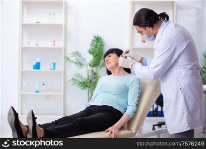 The old woman visiting young doctor laryngologist. Old woman visiting young doctor laryngologist