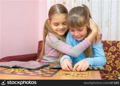 The older sister comforting crying younger sister, which collects a stack of coins