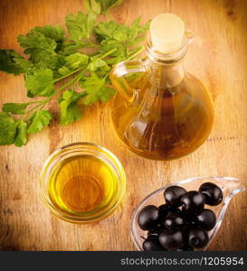 the olives and olive oil on wooden table