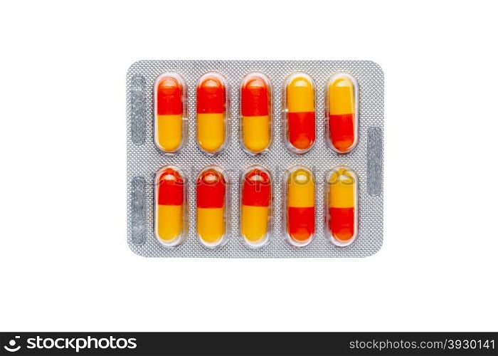 The orange pills in a blister on isolated background. The orange pills in a blister