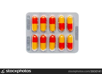 The orange pills in a blister on isolated background. The orange pills in a blister