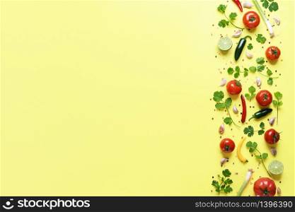 The original salsa sauce ingredients on a yellow background above view. Fresh vegetables, herbs and condiments used to make the mexican salsa sauce.