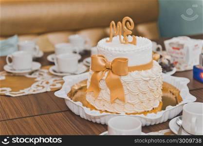 The original wedding cake.. Wedding cake decorated with beige cream on the table 424.