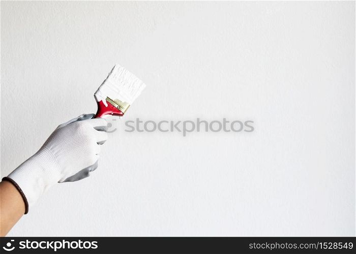 The painter is painting a white foundation in the bedroom wall at home.