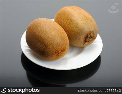 The pair of Kiwi on a white plate on a black background
