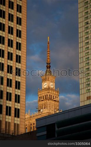 The Palace of Culture and Science in Warsaw Poland was donated by Stalin in 1955. Picture is framed by two modern skyscrapers at sunset