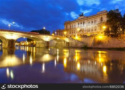 The Palace of Justice in Rome, Italy. The Palace of Justice and bridge Ponte Umberto I with mirror reflection seen from the Tiber riverside during morning blue hour in Rome, Italy