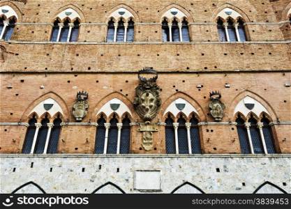 The Palazzo Pubblico and the Torre del Mangia in Siena, Italy, isolated in white.