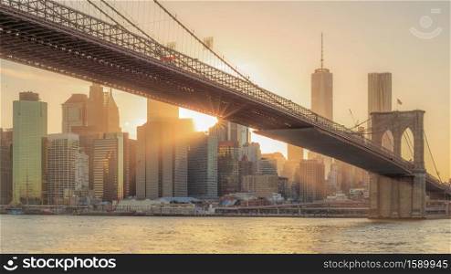 The panorama view of Brooklyn Bridge with Lower Manhattan at sunset in USA