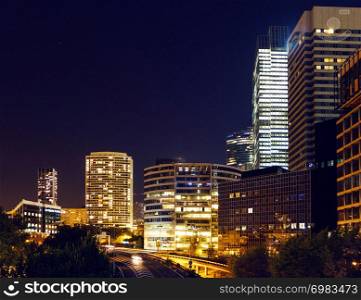 The Paris city at night. Street lights and glass business towers, France. The city of Paris at night