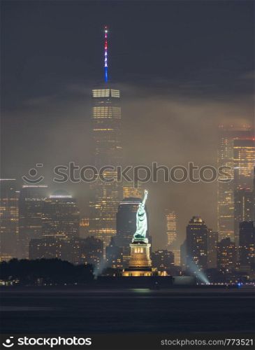 The park lights illuminate Lady Liberty amidst fireworks smoke on July 4th, 2019