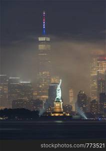 The park lights illuminate Lady Liberty amidst fireworks smoke on July 4th, 2019