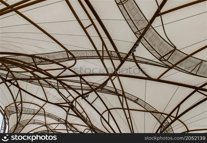 The pattern of steel frame umbrella underside detail with white cloth roof. Selective focus.