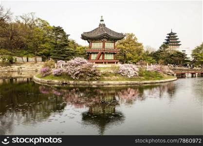 The Pavilion of Far-Reaching Fragrance sits on an artificial island in the Gyeongbokgung Palace complex in Seoul, Korea. The island can only be reached via a bridge that is visible at the right.