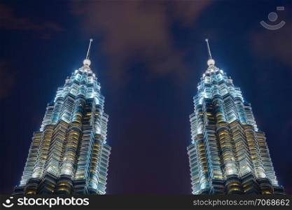 The peak of Petronas Twin Towers. Kuala Lumpur Downtown, Malaysia. Financial district and business centers in smart urban city in Asia. Skyscraper and high-rise buildings at night.
