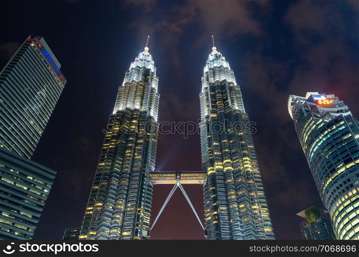 The peak of Petronas Twin Towers. Kuala Lumpur Downtown, Malaysia. Financial district and business centers in smart urban city in Asia. Skyscraper and high-rise buildings at night.
