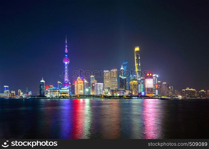 The Pearl in Shanghai Downtown skyline by Huangpu River, China. Financial district and business centers in smart city in Asia. Skyscraper and high-rise buildings near The Bund at night.