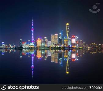 The Pearl in Shanghai Downtown skyline by Huangpu River, China. Financial district and business centers in smart city in Asia. Skyscraper and high-rise buildings near The Bund at night.