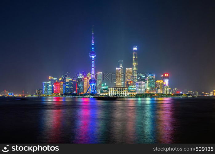 The Pearl in Shanghai Downtown skyline by Huangpu River, China. Financial district and business centers in smart city in Asia. Skyscraper and high-rise buildings near The Bund at night.