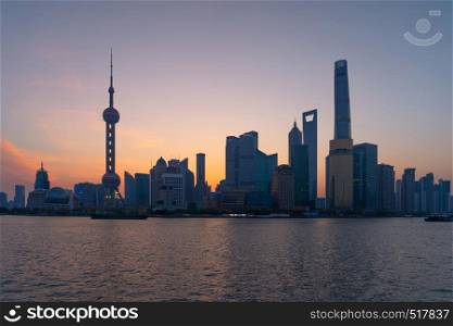 The Pearl in Shanghai Downtown skyline by Huangpu River, China. Financial district and business centers in smart city in Asia. Skyscraper and high-rise buildings near The Bund at sunrise.