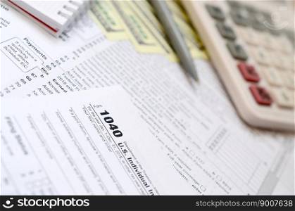 The pen, notebook, calculator, and dollar bills is lies on the tax form 1040 U.S. Individual Income Tax Return. The time to pay taxes