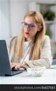 The perfect balance of work and wellness as a woman embraces healthy eating at her workplace. With a bowl of nutritious muesli and yogurt by her side, she savors each bite while efficiently typing on her laptop, optimizing her productivity. Healthy lifestyle at work as a woman finds joy in her nutritious muesli and yogurt.