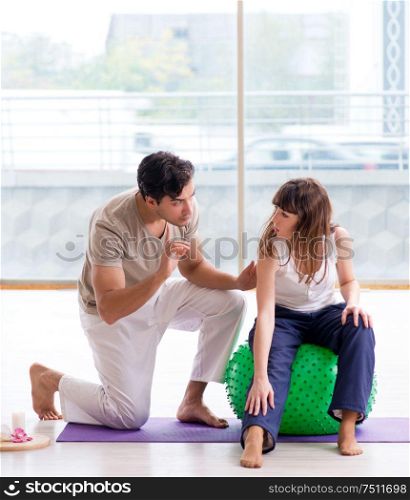 The personal coach helping woman in gym with stability ball. Personal coach helping woman in gym with stability ball