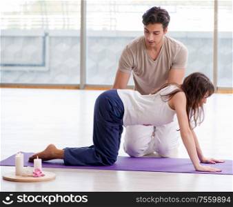 The personal trainer assisting during exercise in sports gym. Personal trainer assisting during exercise in sports gym