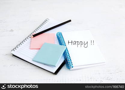 The photo shows a paper notebook with black pen on a white wooden board