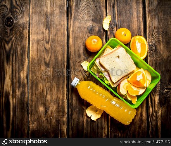 The picnic set. Sandwiches with cheese and bacon, fruit and orange juice.. Sandwiches with cheese and bacon,