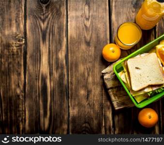 The picnic set. Sandwiches with cheese and bacon, fruit and orange juice.. Sandwiches with cheese and bacon,