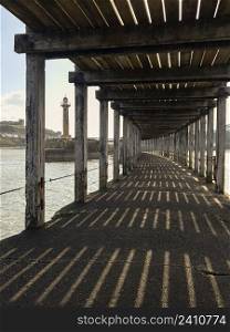The pier at the entrance to the harbor at Whitby on the North Yorkshire coast in the northeast of England.