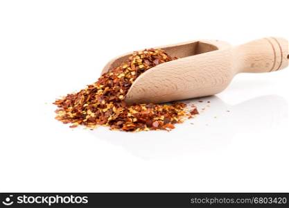 The pile of a crushed red pepper, dried chili flakes and seeds isolated on white background in a scoop