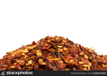 The pile of a crushed red pepper, dried chili flakes and seeds isolated on white background