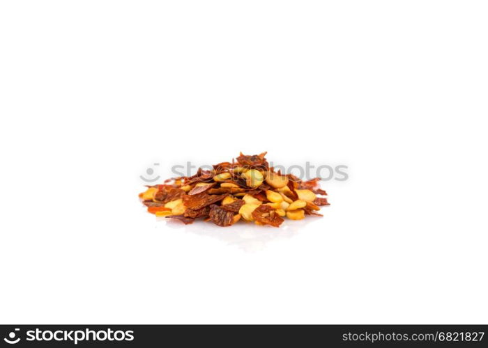 The pile of a crushed red pepper, dried chili flakes and seeds isolated on white background