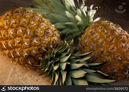 The Pineapple is a large juicy tropical fruit consisting of aromatic edible yellow flesh surrounded by a tough segmented skin and topped with a tuft of stiff leaves. Pineapples are the only bromeliad fruit in widespread cultivation.