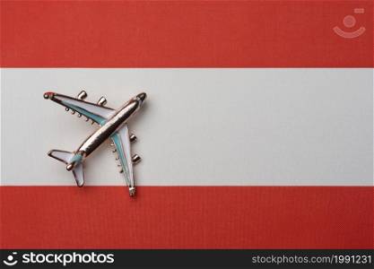 The plane over the flag of Austria, the concept of travel. Toy airplane on the flag as a background.. The plane over the flag of Austria, the concept of travel.