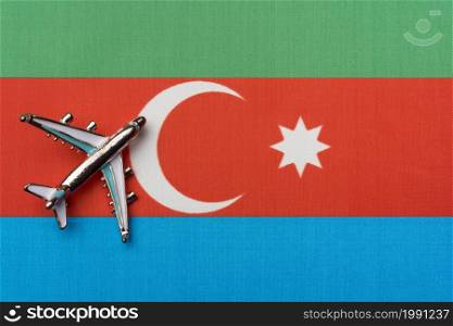 The plane over the flag of Azerbaijan, the concept of travel. Toy airplane on the flag as a background.. The plane over the flag of Azerbaijan, the concept of travel.