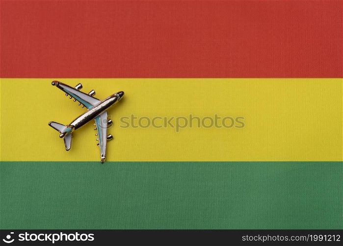 The plane over the flag of Bolivia, the concept of travel. Toy plane on the flag as a background.. The plane over the flag of Bolivia, the concept of travel.