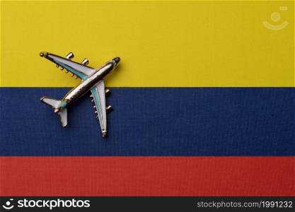 The plane over the flag of Colombia, the concept of travel. Toy airplane on the flag as a background.. The plane over the flag of Colombia, the concept of travel.