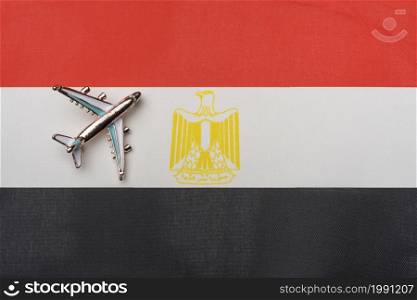 The plane over the flag of Egypt, the concept of travel. Toy plane on the flag as a background.. The plane over the flag of Egypt, the concept of travel.