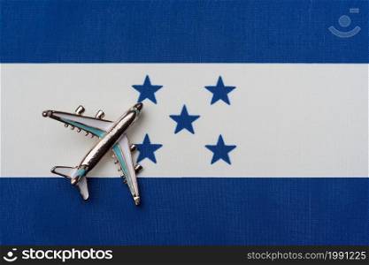 The plane over the flag of Honduras, the concept of travel. Toy plane on the flag as a background.. The plane over the flag of Honduras, the concept of travel.