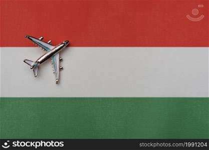 The plane over the flag of Hungary, the concept of travel. Toy plane on the flag as a background.. The plane over the flag of Hungary, the concept of travel.