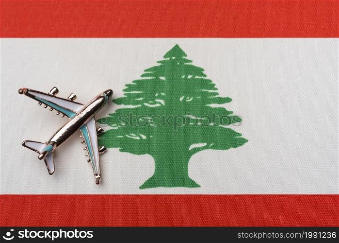 The plane over the flag of Lebanon, the concept of travel. Toy airplane on the flag as a background.. The plane over the flag of Lebanon, the concept of travel.