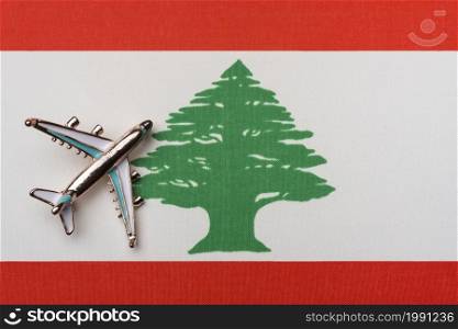 The plane over the flag of Lebanon, the concept of travel. Toy airplane on the flag as a background.. The plane over the flag of Lebanon, the concept of travel.