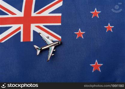 The plane over the flag of New Zealand, the concept of travel. Toy plane on the flag as a background.. The plane over the flag of New Zealand, the concept of travel.