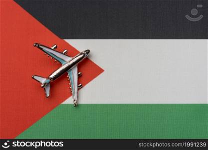 The plane over the flag of Palestine, the concept of travel. Toy airplane on the flag as a background.. The plane over the flag of Palestine, the concept of travel.